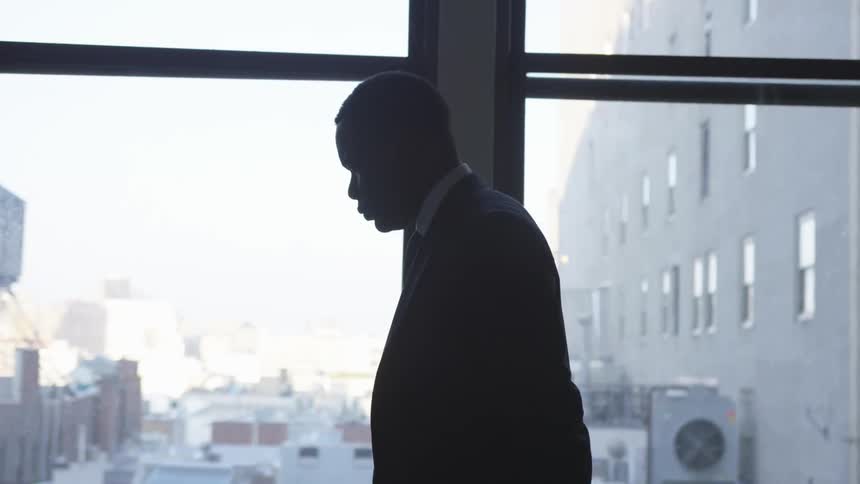 Man paces next to a large window