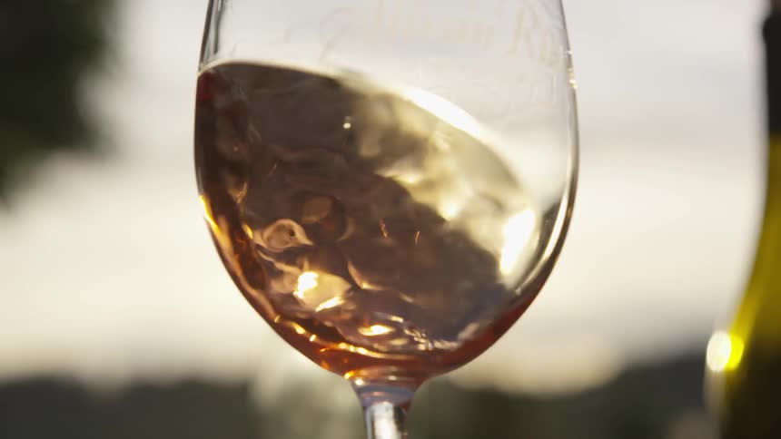 Sun shines through liquid swirling around in a glass