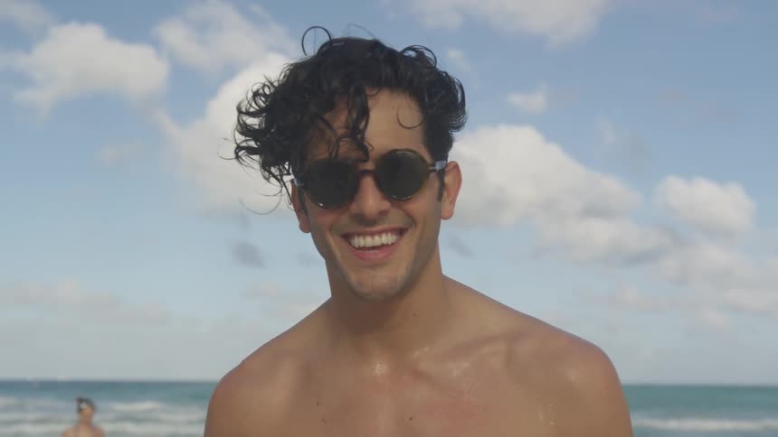 A man is smiling on the beach