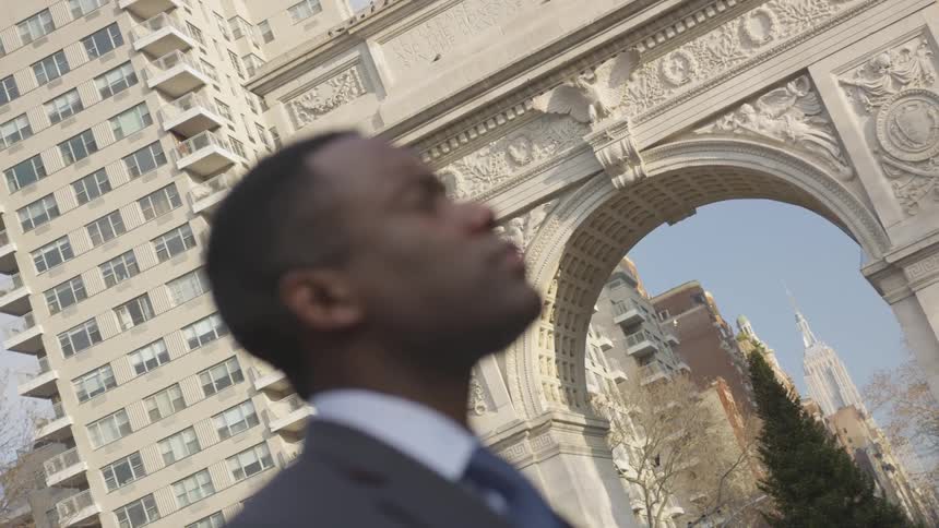 A businessman stands on a city sidewalk