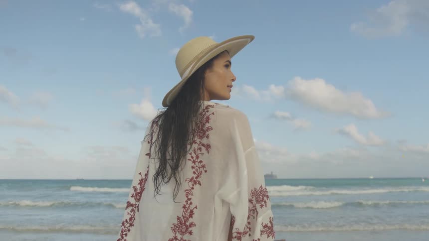 Woman walks on the beach on a clear day