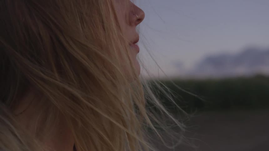 Woman stands outside on a windy evening