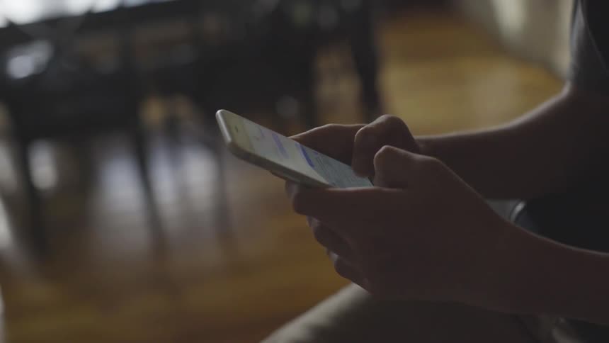 A person types on a cell phone