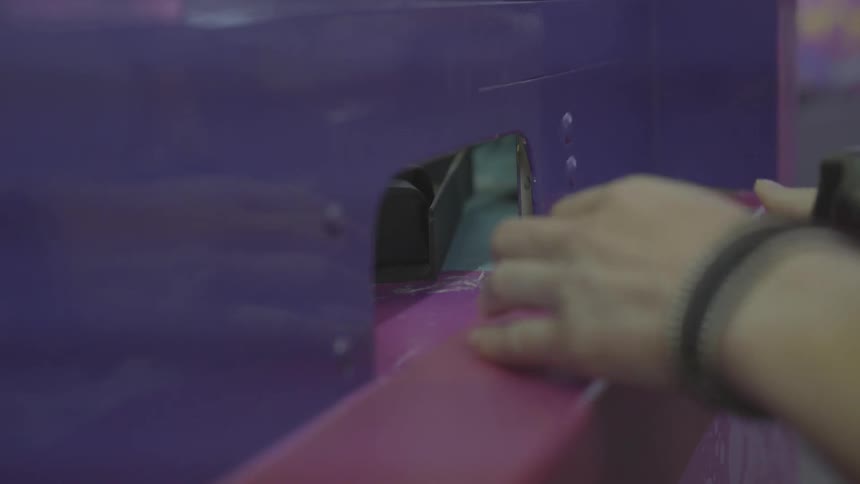 A man puts money through the hole in a ticket booth