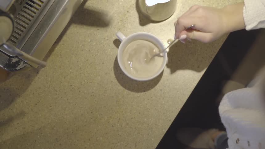A person pours milk then mixes it in