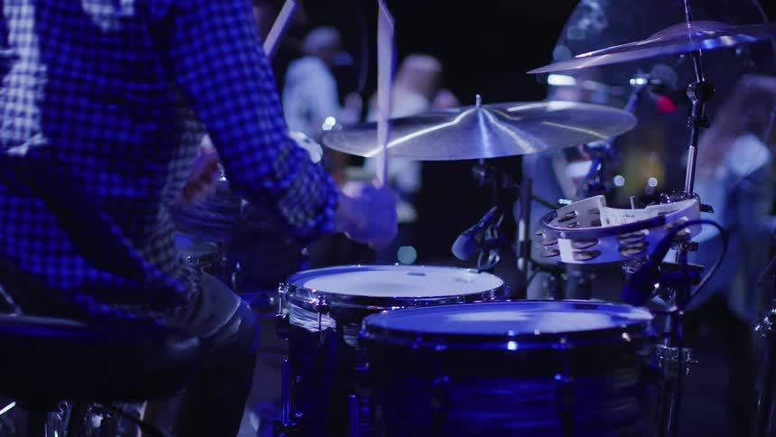 A man plays the drums to the song