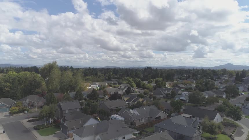 The vehicles travel through the suburban neighborhood
