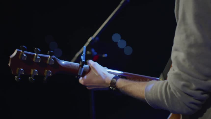 A person is performing on stage with a guitar