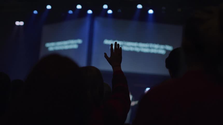People in the audience raise their hands