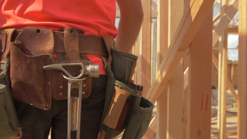 Construction worker is walking through house being built