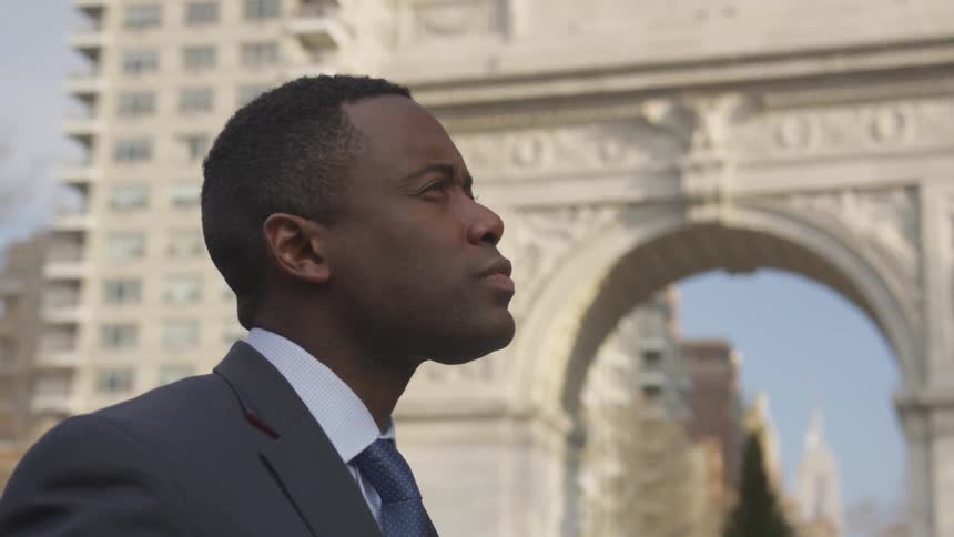 A man is standing in the city on a cloudy day