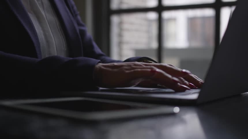 A person types on their laptop
