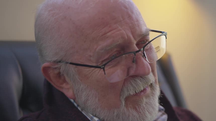 Older man is sitting in chair and talking