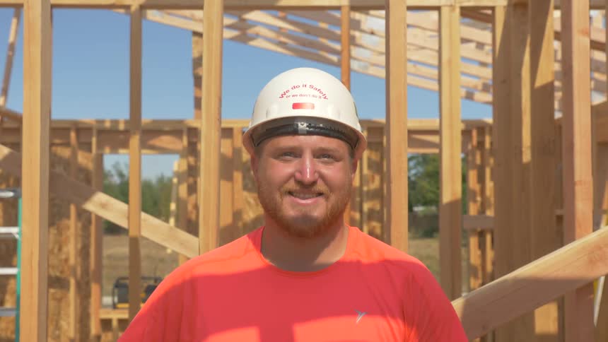 Man wearing a hard hat stands at a construction site