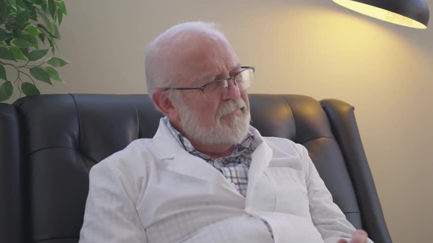 Elderly man sits in a chair in an office
