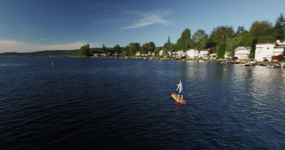 Person stands on a paddle board in a lake