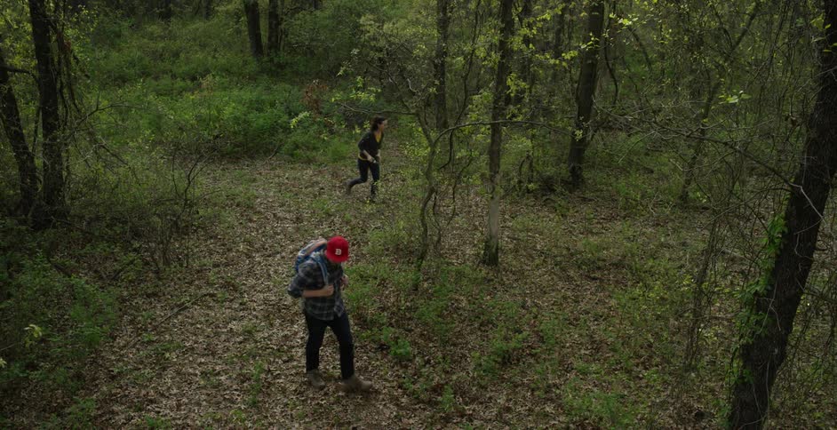 Two people walking in a forest looking around