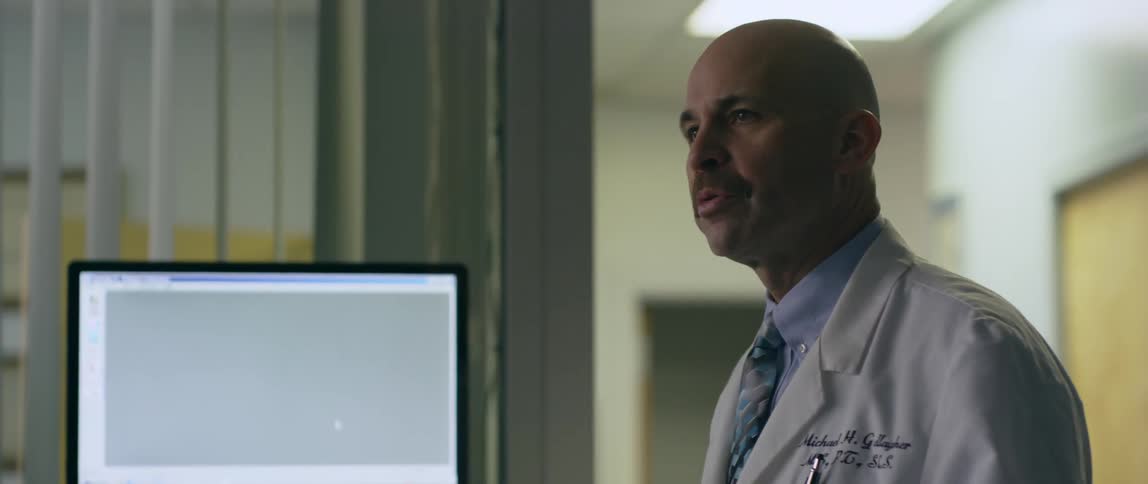 A doctor talks to someone while looking at a monitor