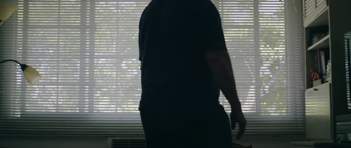 A man walks toward a window