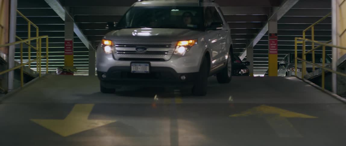 An suv drives down a ramp in a parking garage