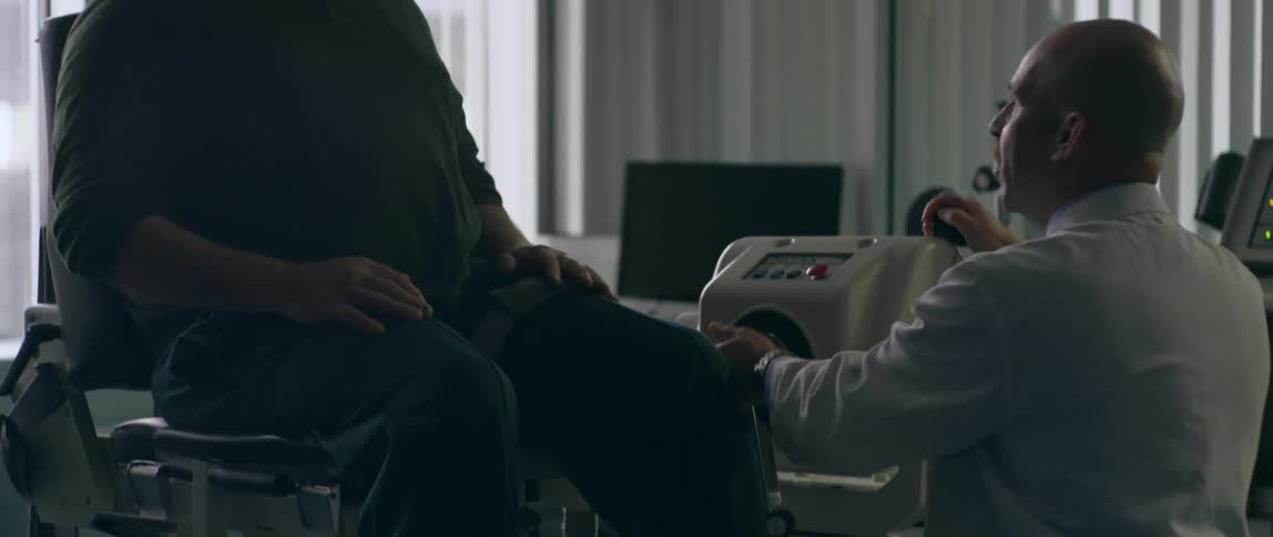 Doctor talks to a man in a wheelchair