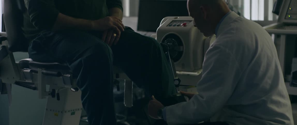 Doctor adjusts strap around a man's ankle