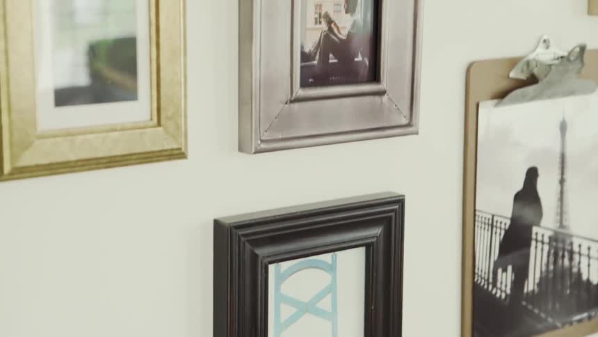 Several framed pictures hanging on a white wall