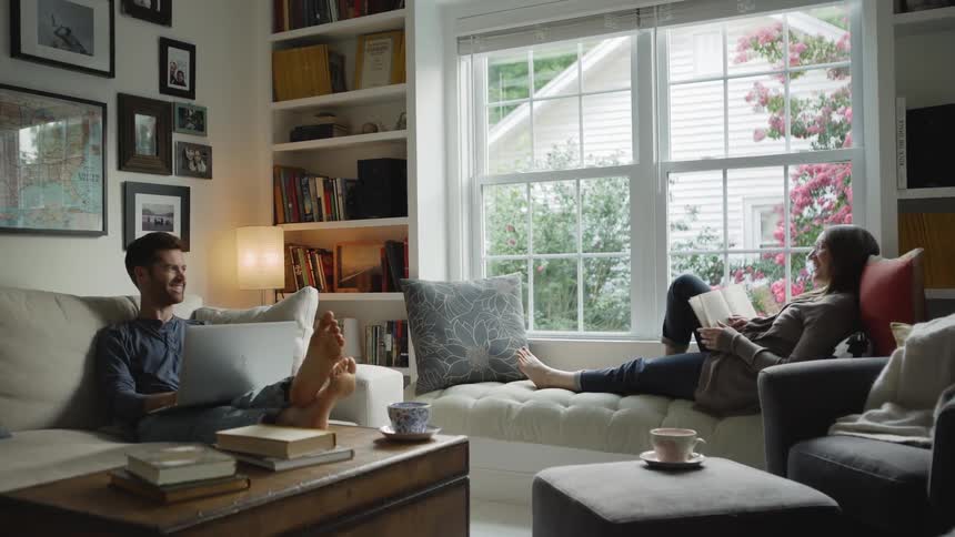 Couple Laugh and Smile at Each Other in Living Room