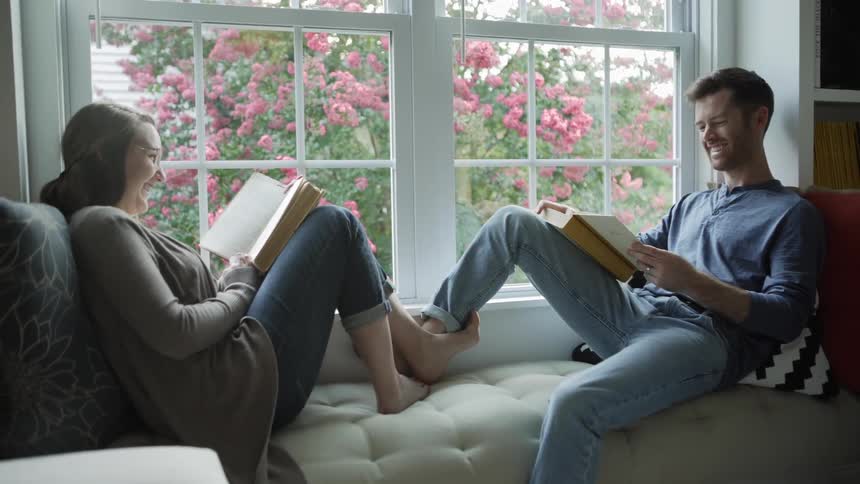 The two people sit with books together