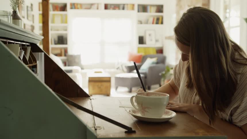 Woman sits at a desk writing
