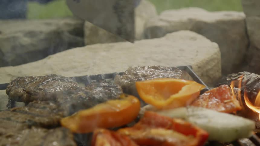 A person flips the food on the grill