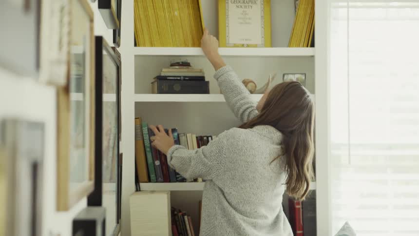Woman Looks at Nat Geo Magazines on a Shelf