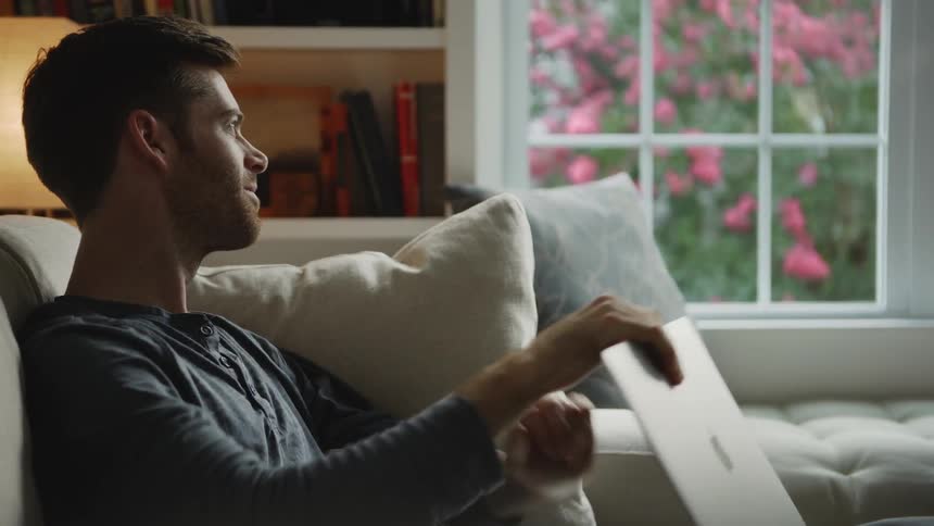 The man smiles on the couch