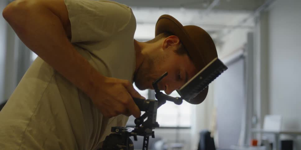 A man adjusts a camera stand
