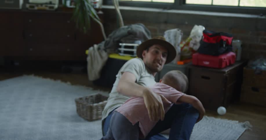 Man plays with child on the living room floor
