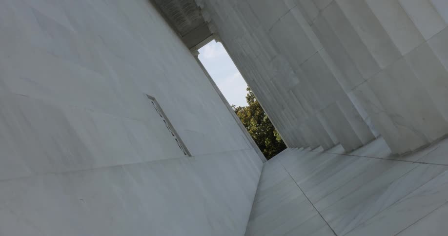A building with columns and trees growing around it