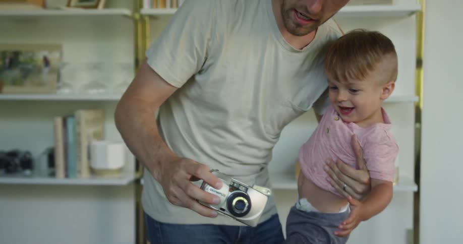 A man shows a baby the camera