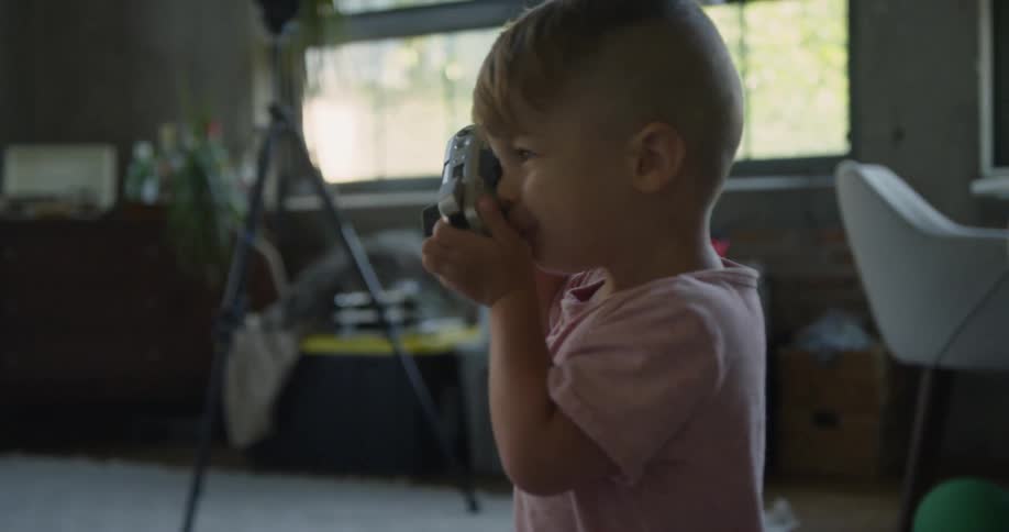 A boy holds a camera up