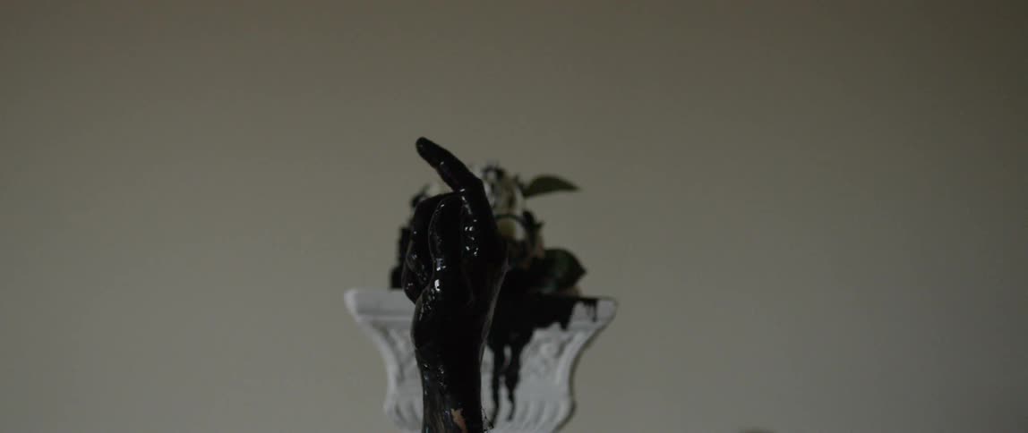 A hand is covered in black paint