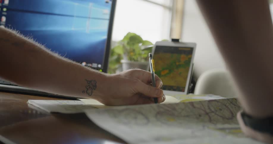 A man writes while standing at a desk