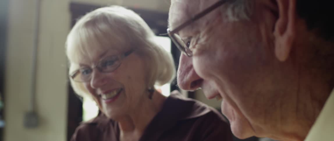 A man and woman with glasses talk together