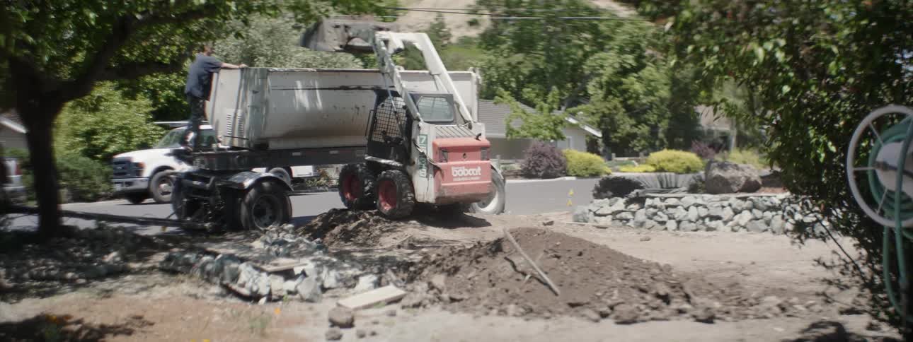 Machinery scoops up some dirt and dumps it into a large bin
