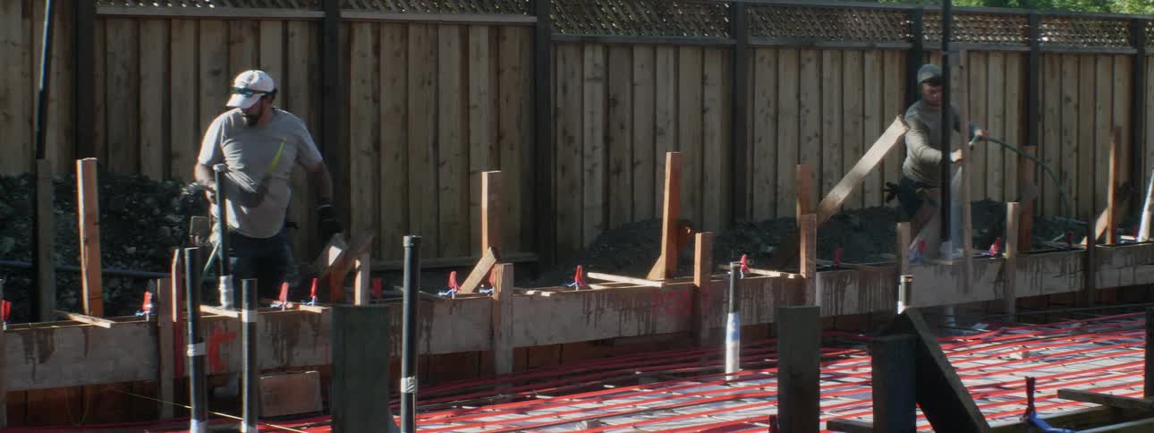 Men work at a construction site in a backyard