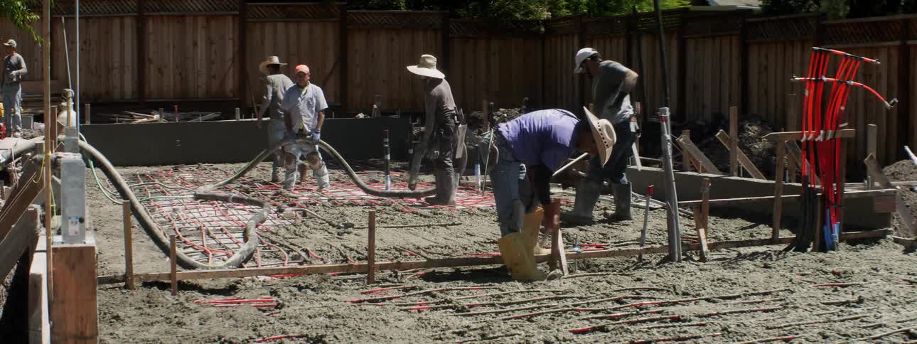 Several construction workers build a house