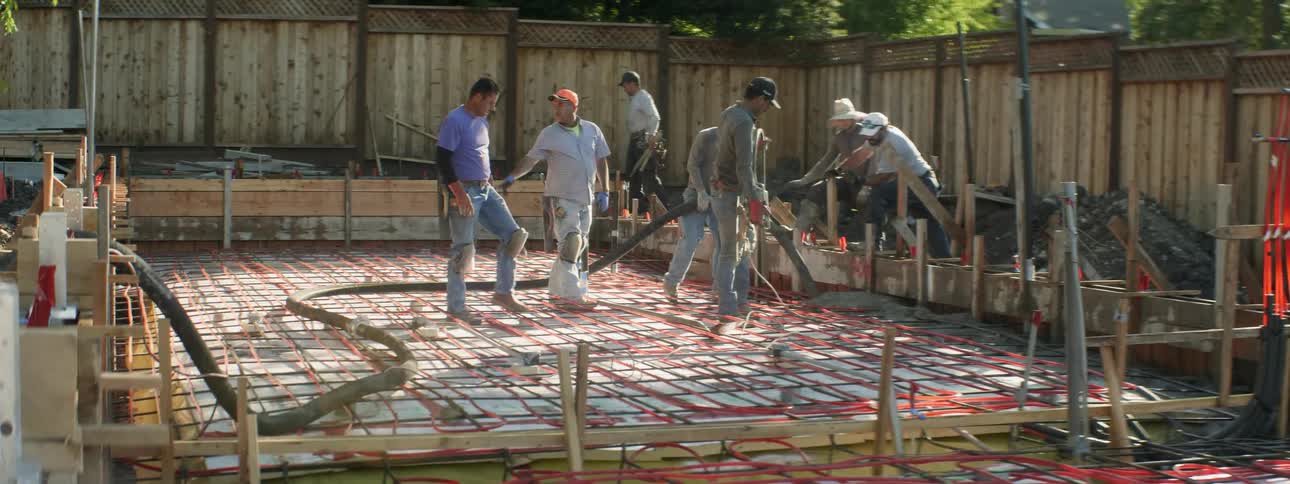 Men work at a construction site in a backyard