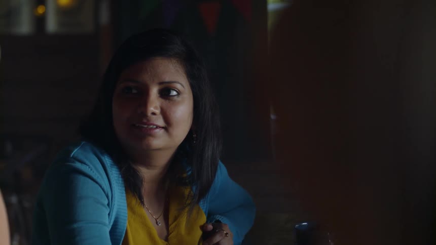 Women smile while having a conversation indoors