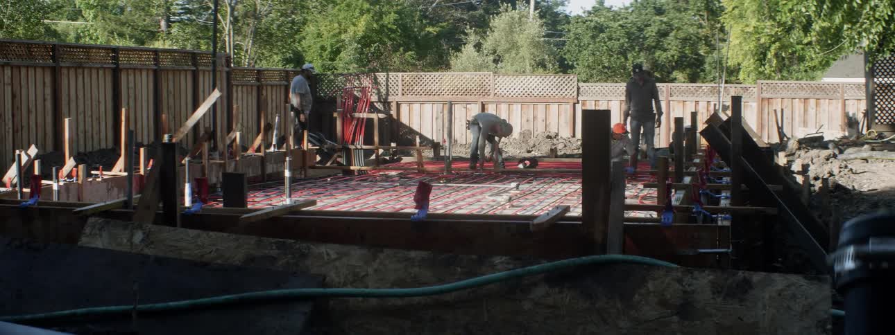 A construction crew works in a backyard