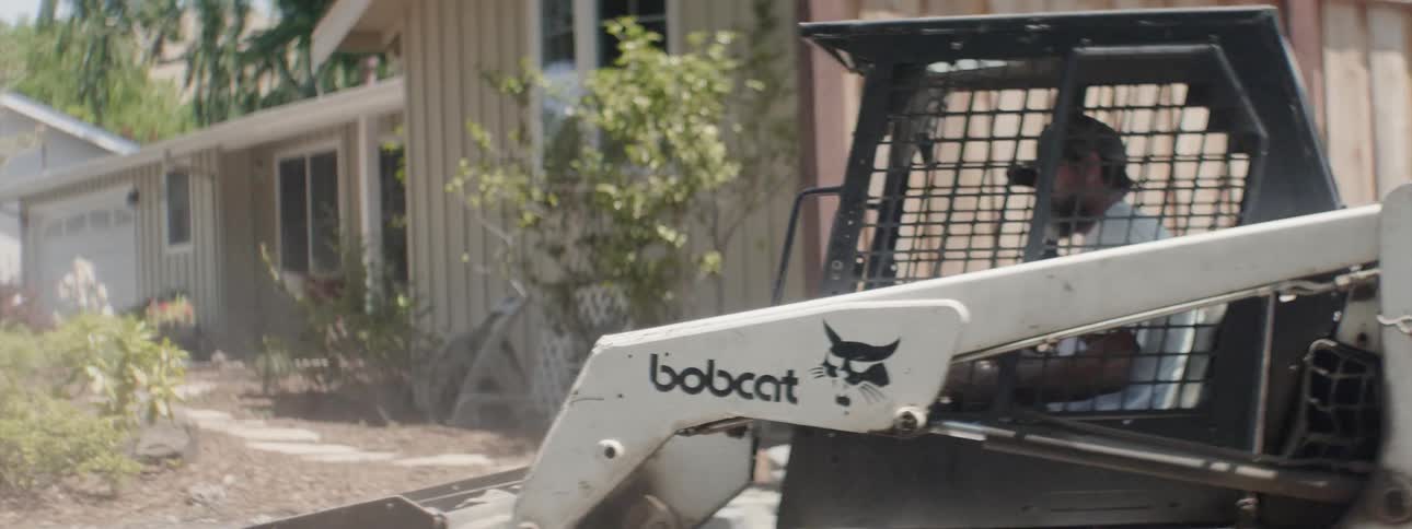 The bulldozer is moving soil around the yard