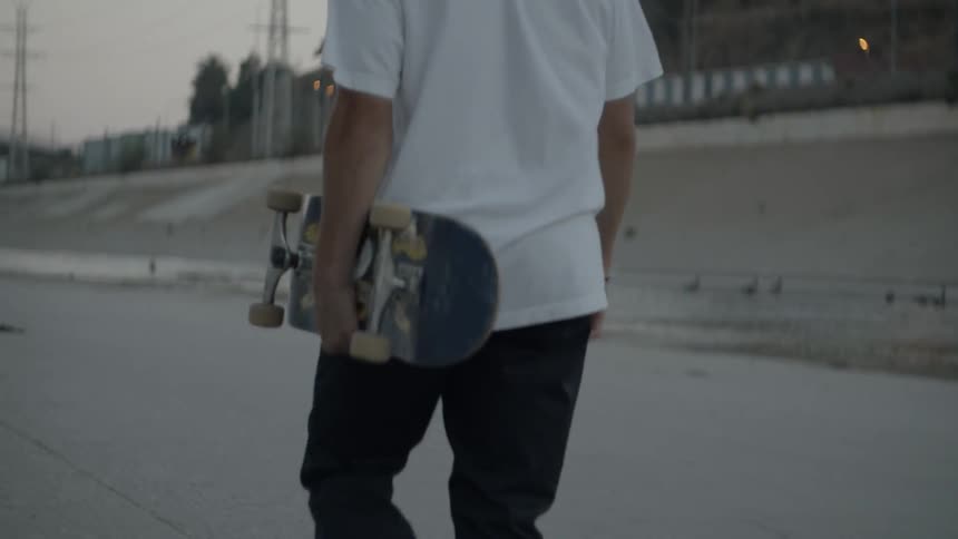Teen Walks With Skateboard