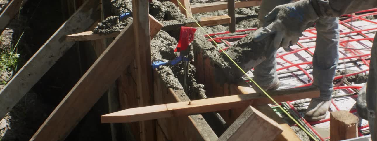A construction worker pours concrete